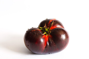 Fresh ripe black tomato isolated on a white background. Krim or Kumato tomatoes.	