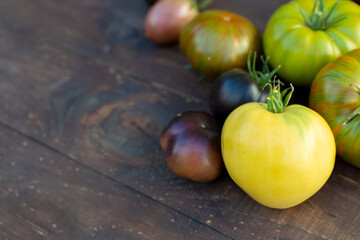 Colorful tomatoes of different varieties on a brown wooden table
