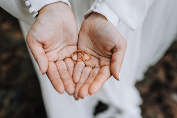 Golden rings in the hands of the bride close-up. Wedding photography, portrait.