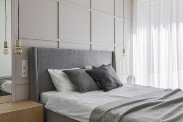 Modern minimalist bedroom interior design with grey furniture, oak floor in Scandinavian style.  Aesthetic simple interior design concept.