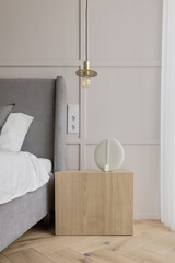 Fototapeta na wymiar Modern minimalist bedroom interior design with grey furniture, oak floor in Scandinavian style. Aesthetic simple interior design concept.