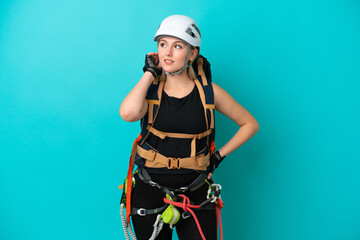 Young caucasian rock climber woman isolated on blue background thinking an idea