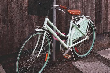 Fototapeta na wymiar Mint green retro bicycle parked against rustic dark wood wall