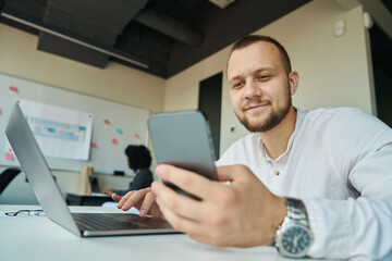 Manager works in the office with phone and laptop