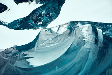 Texture of transparent blue glass on a light background.