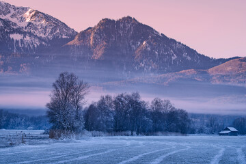 Gefrorene Landschaft mit Bergen und Felder bei Sonnenaufgang an einem kalten Winter Morgen -...