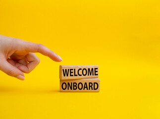 Welcome onboard symbol. Concept words Welcome onboard on wooden blocks. Beautiful yellow background. Businessman hand. Business and Welcome onboard concept. Copy space.