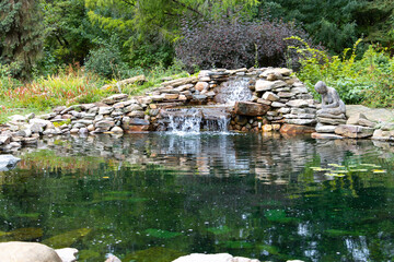 Fototapeta na wymiar waterfall flowing into green pond