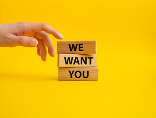We want you symbol. Concept words We want you on wooden blocks. Beautiful yellow background. Businessman hand. Business and We want you concept. Copy space.