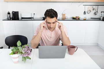 Young businessman working on laptop at home. Distant work concept	