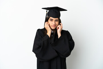Young university graduate isolated on white background frustrated and covering ears