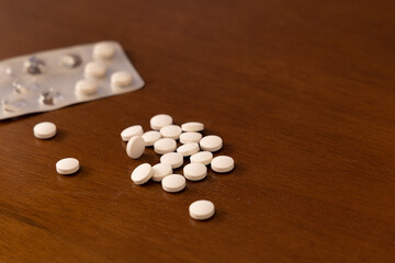 Fototapeta na wymiar Medicine pills on wooden surface. Selective focus.