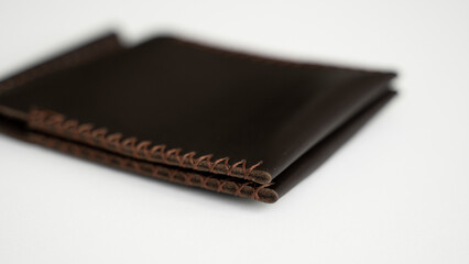 Brown money clip handmade from genuine leather on white surface.