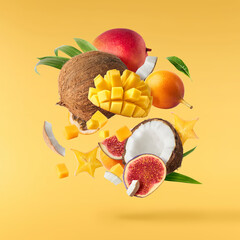 Exotic fruit mix, pineapple, coconuts, mango, fig, passiflora, carambola falling in te air