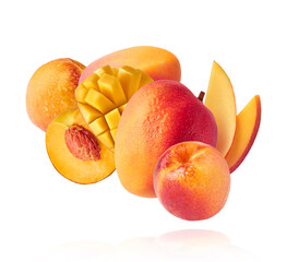 Fresh ripe whole and sliced mango and peaches with green leaves falling in the air