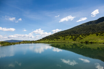 Naklejka na ściany i meble blue sky reflection in the water surface of a mountain lake, Carpathians mountains