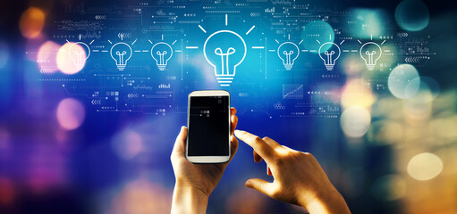 Idea light bulb theme with person using a smartphone