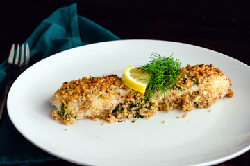 Walnut-Crusted Halibut in Lemon Wine Sauce Viewed from the Side: Baked white fish fillet garnished...