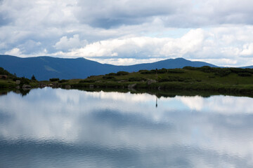 The water surface of a calm lake against the background of the Gorgan mountain range