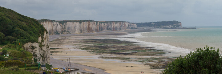 Panorama with high angle view at white cliffs with beach on a cloudy day during low tide in Veules...