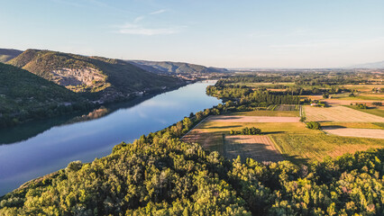 Aerial view of the Rhone River. In the vicinity of the town of Le Pouzin - France. During sunset. Trees that cast a shadow over the surrounding fields