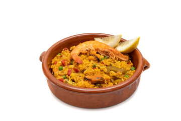 Paella, Seafood Paella in a clay pot, isolated on white background. The Spanish word paella comes...