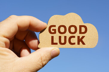 Against the background of the sky in the hands of a man, a figure of a cloud with the inscription - Good luck