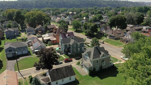 A slowly orbiting summer aerial establishing shot of a typical Western Pennsylvania upscale residential neighborhood.  Pittsburgh suburbs.  	