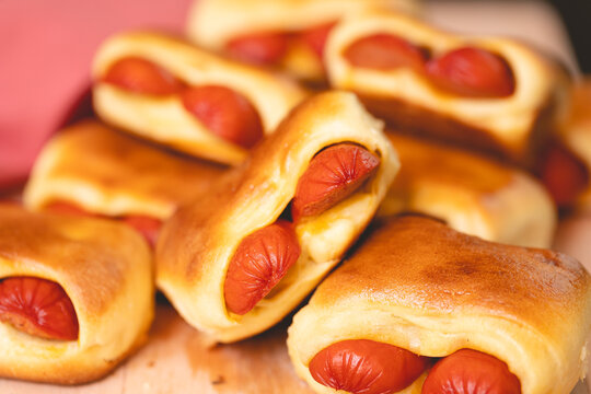 Cachorro-quente assado com massa de p&atilde;o (hot dog s&iacute;rio) ou enroladinho de salsicha na massa de p&atilde;o. Salgado tradicional no Brasil. Comida brasileira. Cachorro quente.