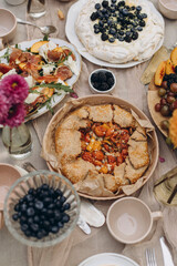 galette with tomatoes on the table top view close-up. dish with tomato pie on the table with other snacks.