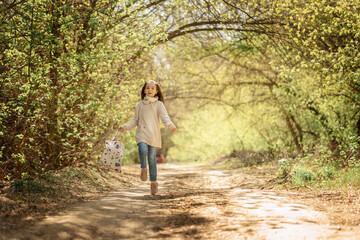 Fototapeta na wymiar Little pretty girl on walk in sunny spring park. Fairy forest. High quality photo