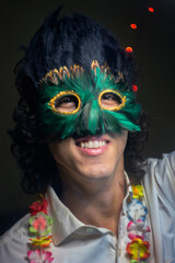 Young guy smiles in the middle of a night party scene in Latin America, Venezuela.