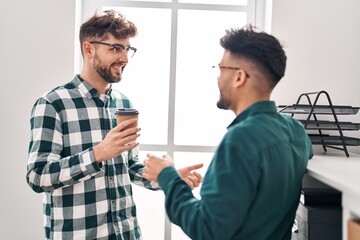 Fototapeta premium Young couple business workers drinking coffee standing at office