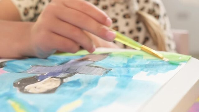 Close up Talented little girl Female Artist Draws Mother Sun Summer Flover drawing at Home. Colorful, Emotional Happy painting with Brush water colors. Contemporary Painter Creating Abstract Modern