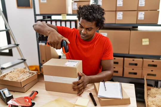 Young south east man using barcode reader device working at storehouse