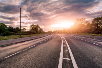 Fototapeta premium Empty high way road at sunrise. Sun flare. Nobody. Transportation industry.