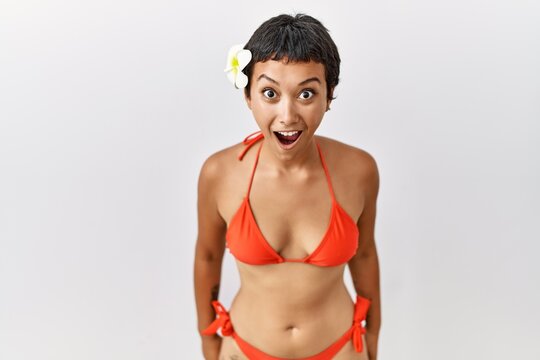 Young hispanic woman with short hair wearing bikini afraid and shocked with surprise and amazed expression, fear and excited face.