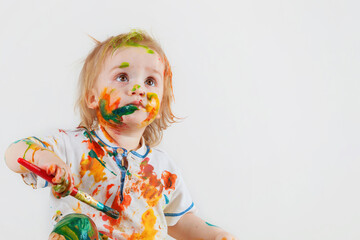 The innocent look of a child who randomly painted his face and clothes with paint. Children's pranks