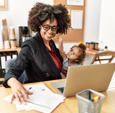 Young african american woman smiling confident working with baby at office