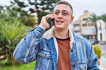 Young hispanic man smiling confident talking on the smartphone at park