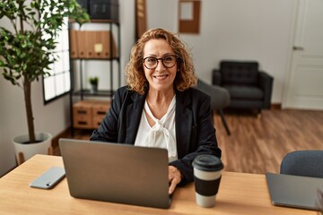 Middle age caucasian businesswoman using laptop working at the office.