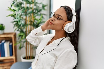 Young african american woman smiling confident listening to music at waiting room