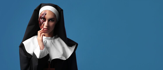 Woman dressed as nun for Halloween on blue background with space for text