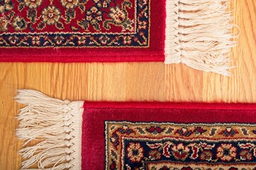 Oriental rug with fringe on hardwood oak floor.