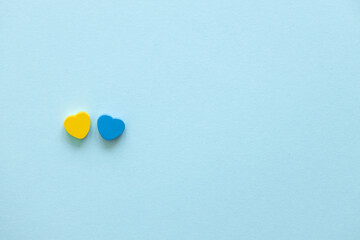 Two hearts of color Ukraine flag on blue background