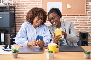 Fototapeta na wymiar African american women business workers using smartphone working at office