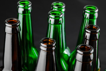 Different open empty beer bottles on black background.