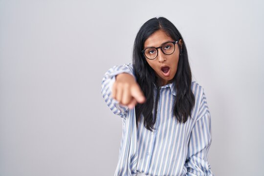 Young hispanic woman wearing glasses pointing displeased and frustrated to the camera, angry and furious with you