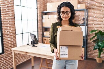 Hispanic woman with dark hair working at small business ecommerce holding boxes skeptic and nervous, frowning upset because of problem. negative person.