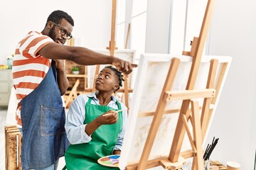 African american painter couple with serious expression painting at art studio.